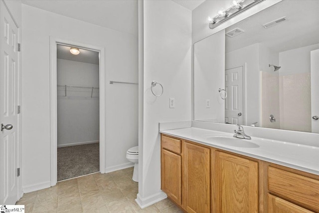 bathroom with vanity, toilet, and walk in shower