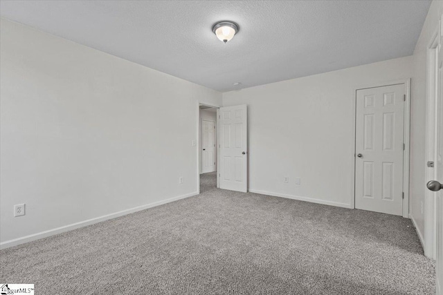 carpeted empty room with a textured ceiling