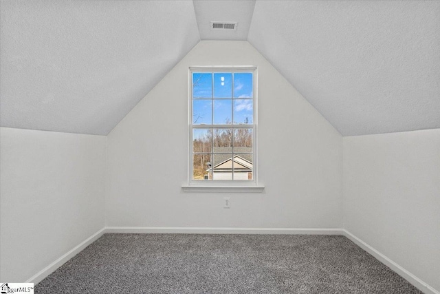 bonus room with carpet flooring and vaulted ceiling