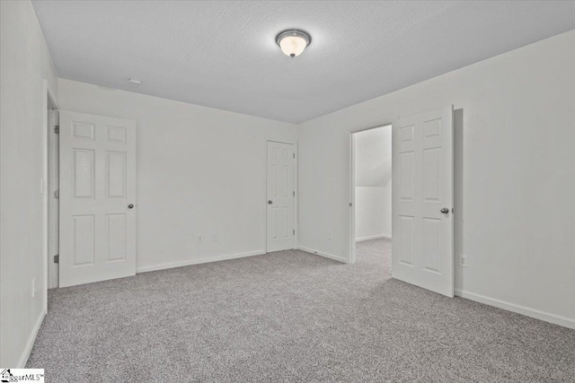 carpeted spare room featuring a textured ceiling