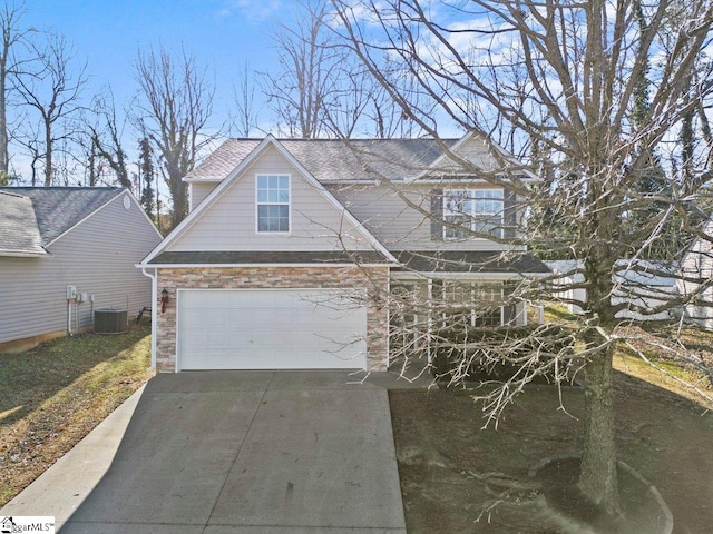 view of front of property featuring a garage and cooling unit