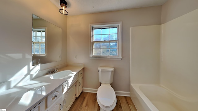 full bathroom featuring hardwood / wood-style floors, vanity, shower / bathtub combination, and toilet