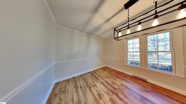 unfurnished dining area with wood-type flooring and crown molding