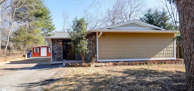 view of front of property featuring a shed