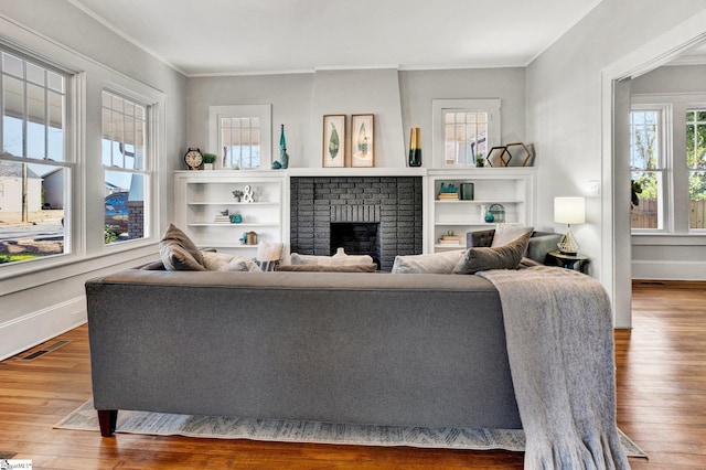 living room featuring a fireplace, crown molding, and hardwood / wood-style floors