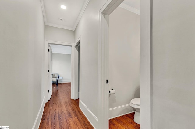 hallway with hardwood / wood-style floors and crown molding