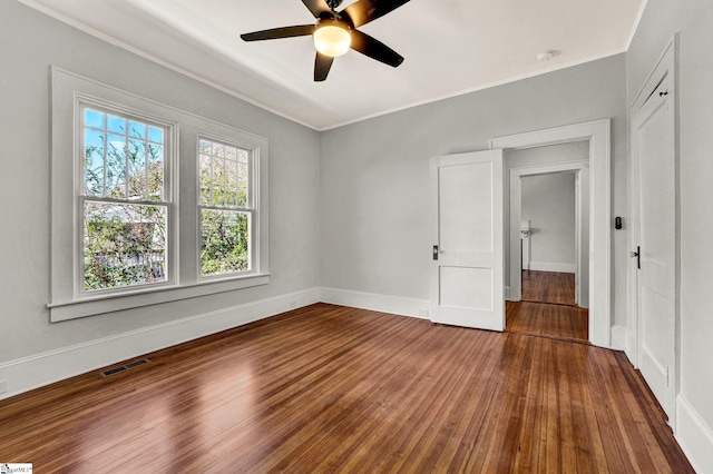 spare room with wood-type flooring, ceiling fan, and crown molding