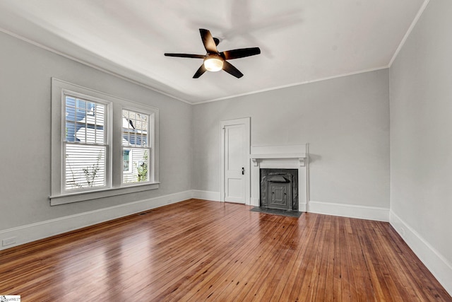 unfurnished living room with wood-type flooring, ceiling fan, and ornamental molding