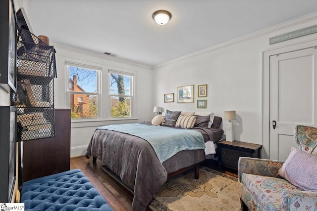 bedroom with crown molding and dark hardwood / wood-style flooring