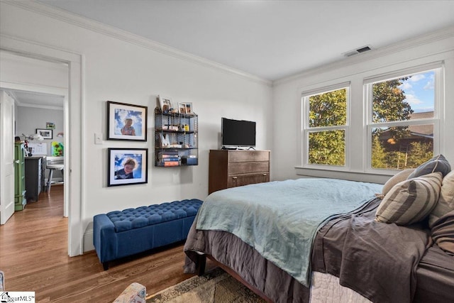 bedroom with crown molding and dark wood-type flooring