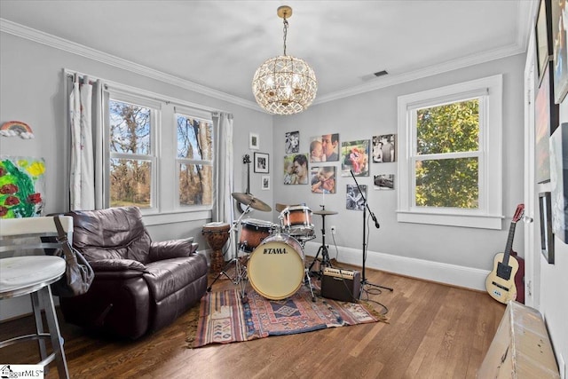 game room with crown molding, wood-type flooring, and an inviting chandelier