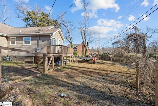 view of yard featuring a deck and a trampoline