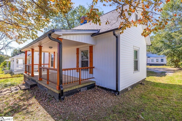 view of home's exterior featuring a porch and a yard