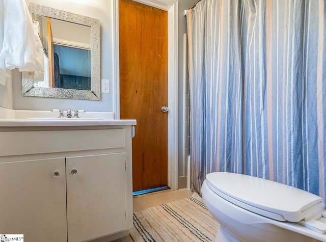 bathroom featuring vanity, toilet, and curtained shower