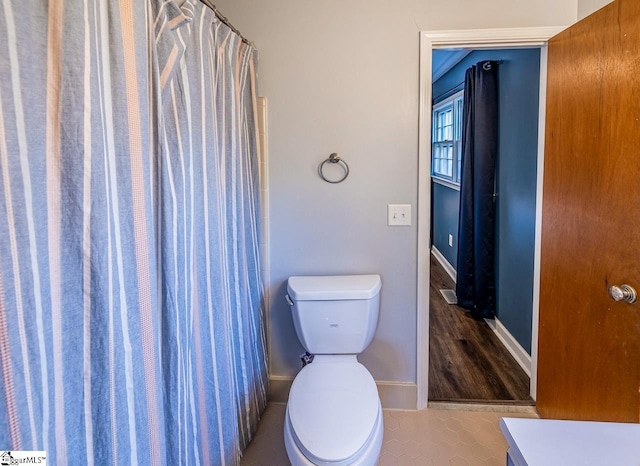 bathroom featuring tile patterned floors, vanity, toilet, and walk in shower