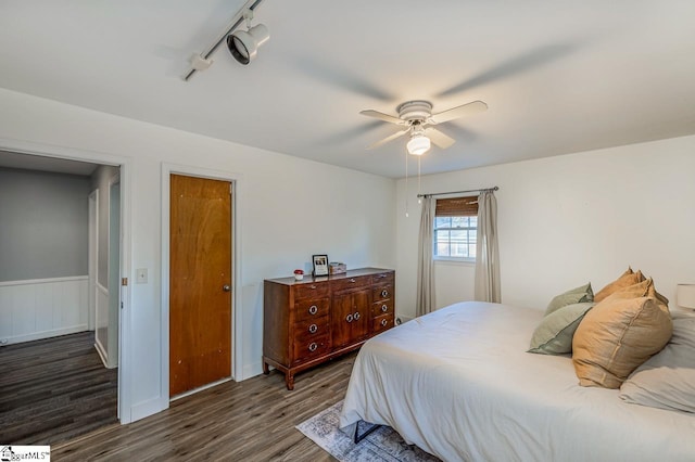 bedroom featuring rail lighting, ceiling fan, and dark wood-type flooring