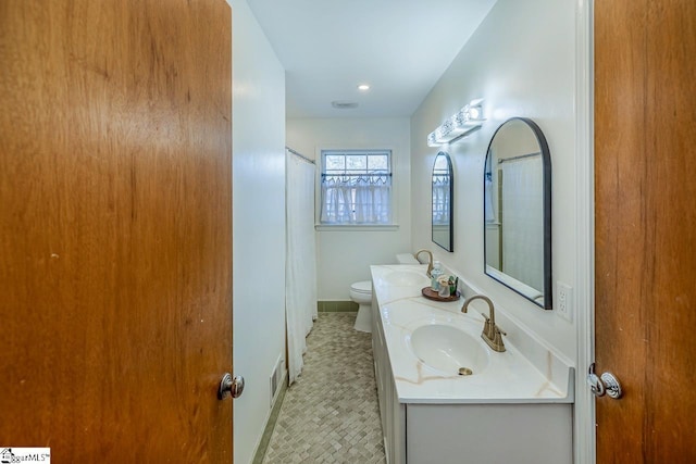 bathroom with tile patterned flooring, vanity, and toilet