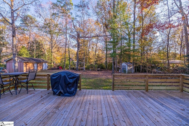 wooden deck featuring a storage shed and grilling area