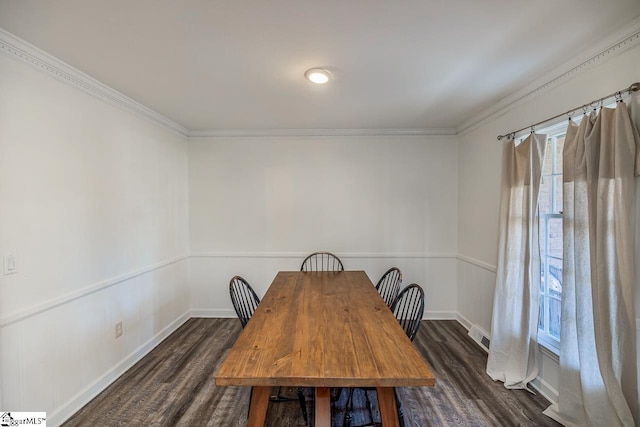 dining space featuring dark wood-type flooring and crown molding