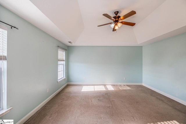 spare room featuring a tray ceiling, ceiling fan, and carpet floors