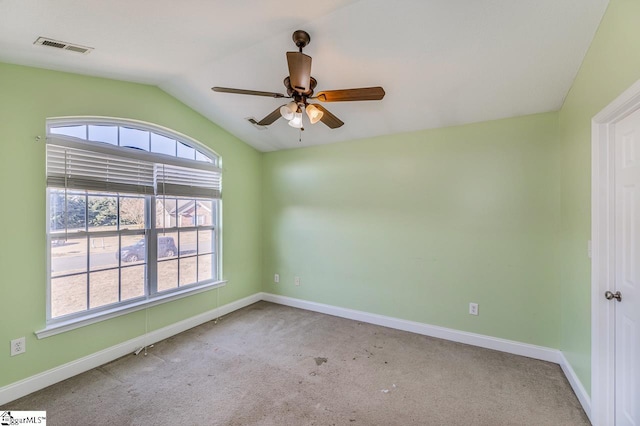 carpeted spare room featuring ceiling fan and lofted ceiling