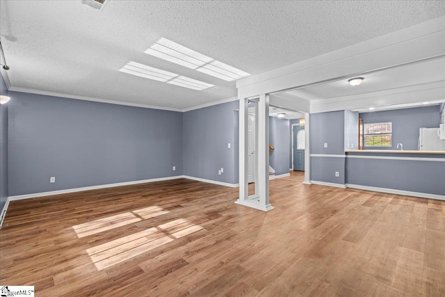 basement featuring hardwood / wood-style floors, white fridge, crown molding, and a textured ceiling