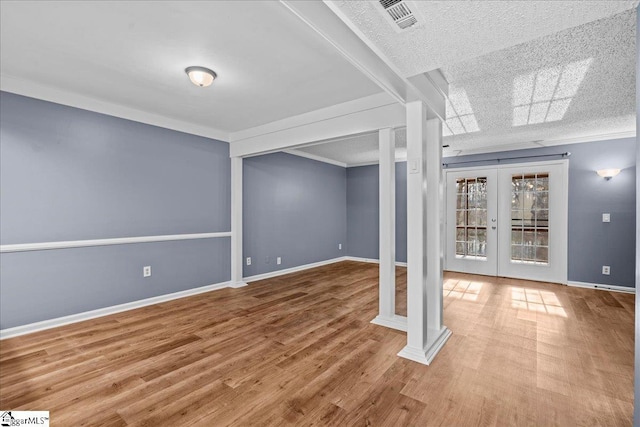 basement with french doors, wood-type flooring, and a textured ceiling