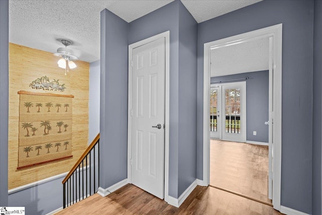 hallway featuring hardwood / wood-style flooring and a textured ceiling