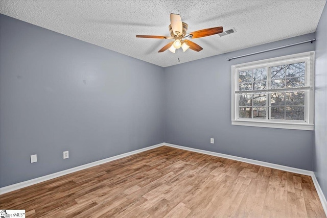 spare room featuring ceiling fan, wood-type flooring, and a textured ceiling