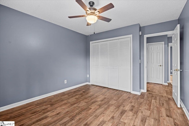 unfurnished bedroom with ceiling fan, a textured ceiling, and a closet