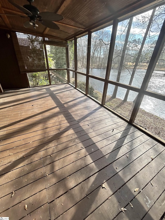 unfurnished sunroom with ceiling fan, a water view, and wooden ceiling