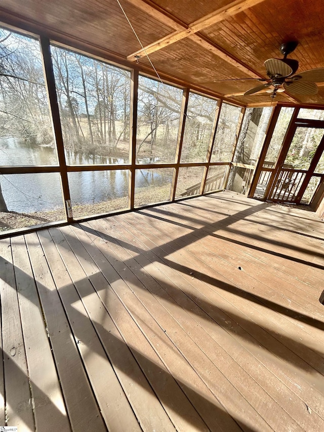 unfurnished sunroom with a wealth of natural light, a water view, wood ceiling, and ceiling fan