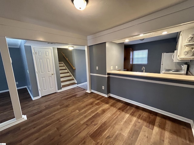 interior space featuring white refrigerator, wood-type flooring, and white cabinetry