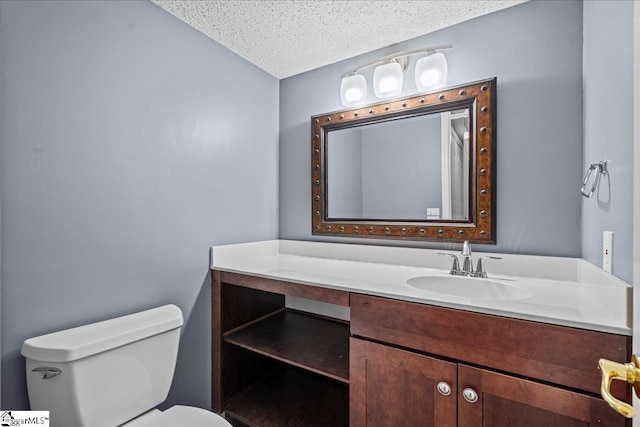 bathroom with vanity, a textured ceiling, and toilet