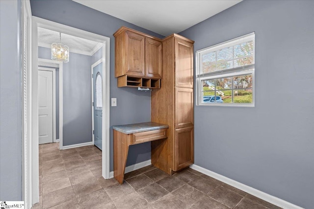 mudroom with crown molding and a chandelier