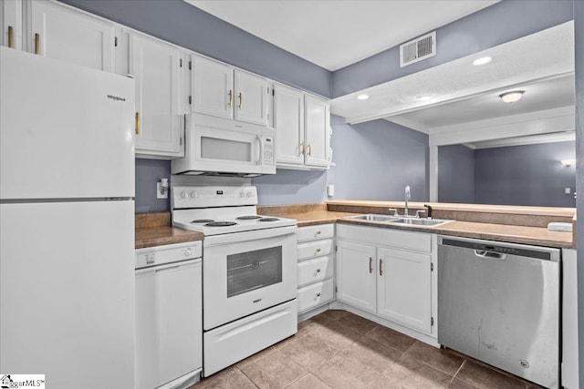 kitchen with white cabinets, light tile patterned floors, white appliances, and sink