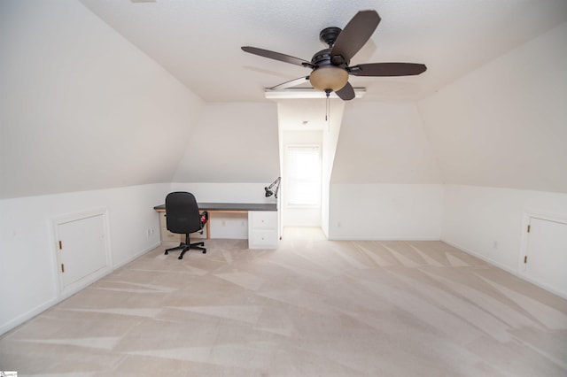 unfurnished office featuring ceiling fan, light colored carpet, and lofted ceiling