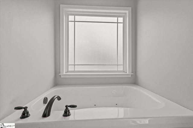 bathroom featuring a tub to relax in and plenty of natural light