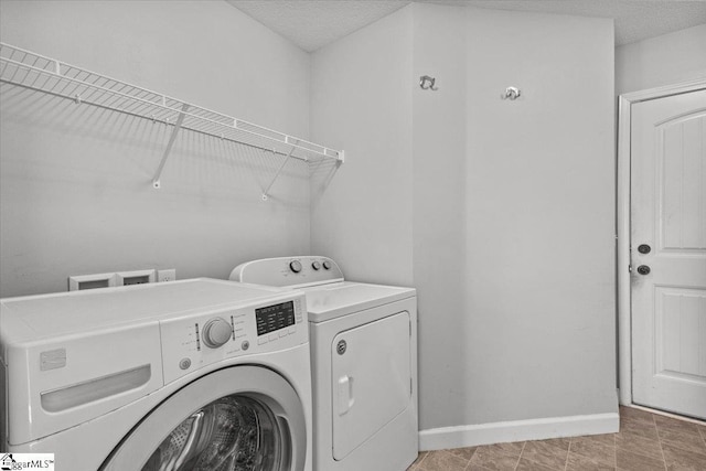 clothes washing area featuring washer and clothes dryer and a textured ceiling