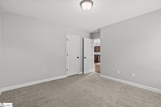 spare room featuring carpet and a textured ceiling