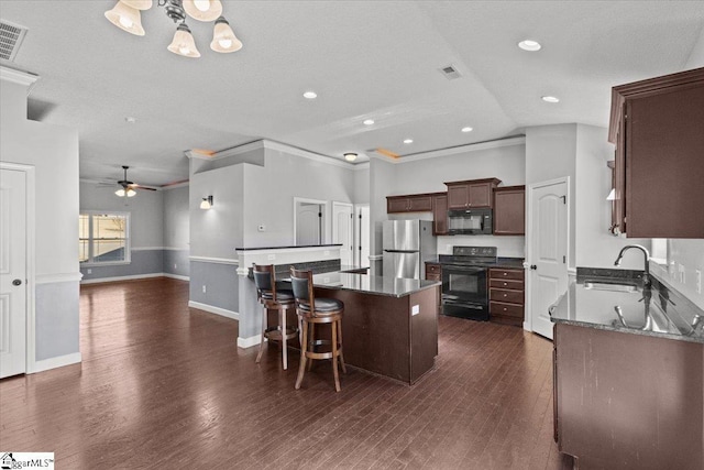 kitchen featuring ceiling fan, crown molding, sink, black appliances, and a center island