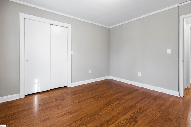 unfurnished bedroom featuring a closet, ornamental molding, and hardwood / wood-style flooring