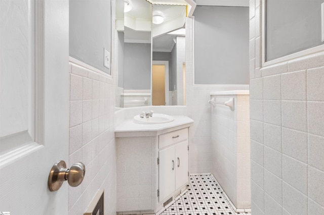 bathroom with tile patterned flooring, vanity, tile walls, and ornamental molding