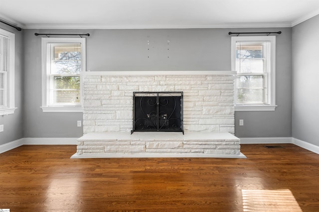 interior details featuring hardwood / wood-style floors, a stone fireplace, and ornamental molding