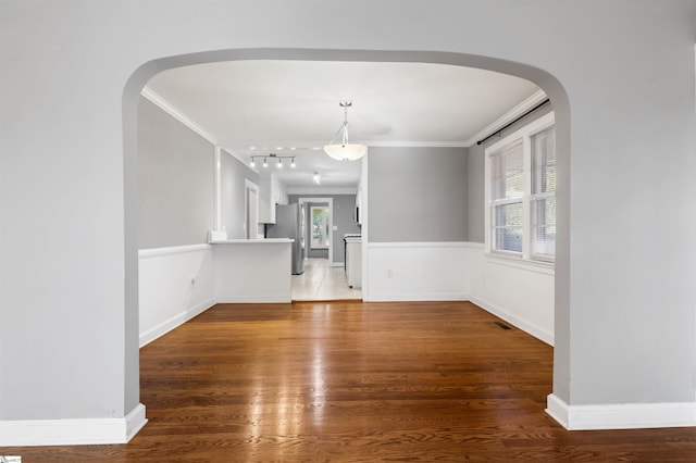 unfurnished living room featuring hardwood / wood-style flooring and crown molding