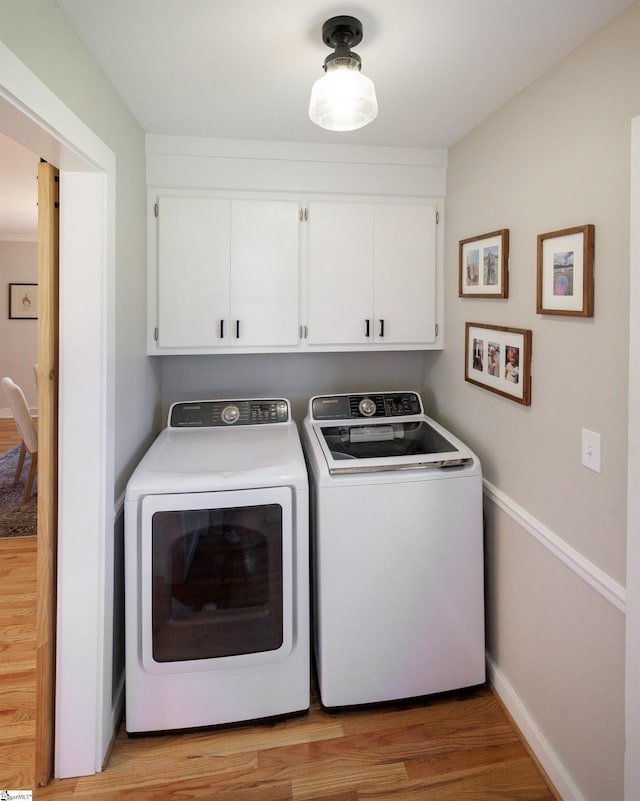 washroom featuring cabinets, light wood-type flooring, and washer and dryer