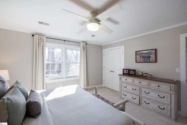 carpeted bedroom featuring ceiling fan, ornamental molding, and a closet