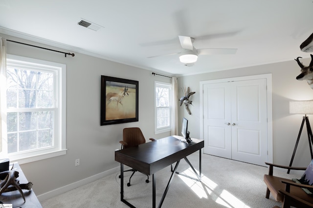 carpeted home office featuring crown molding and ceiling fan