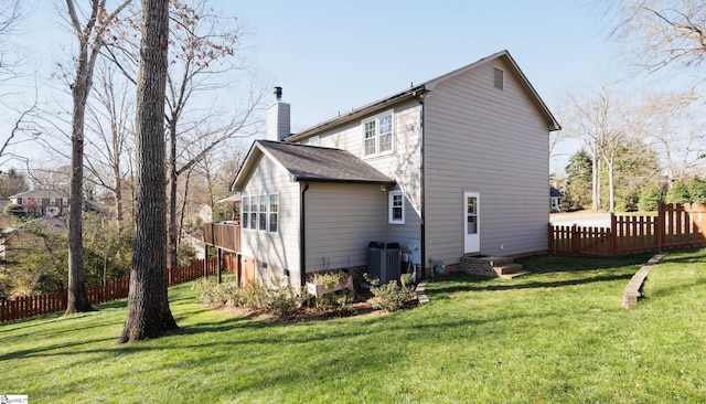 rear view of property with a yard and central AC unit