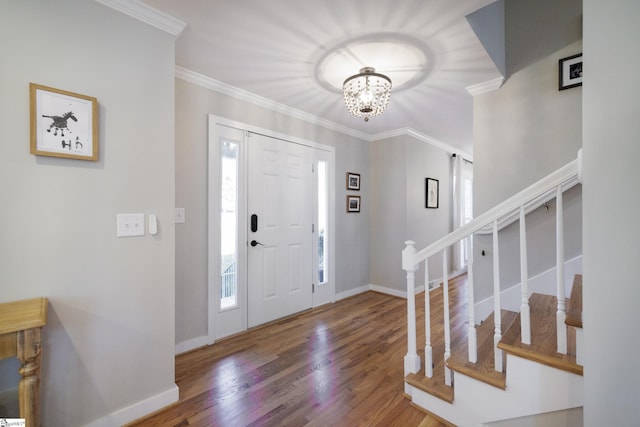 foyer entrance featuring a chandelier, wood-type flooring, and crown molding